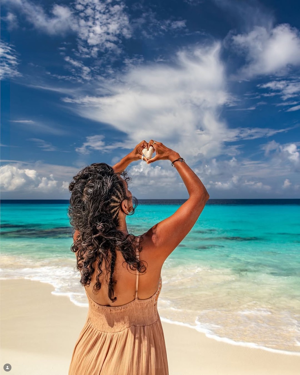 Tara making a heart toward the ocean