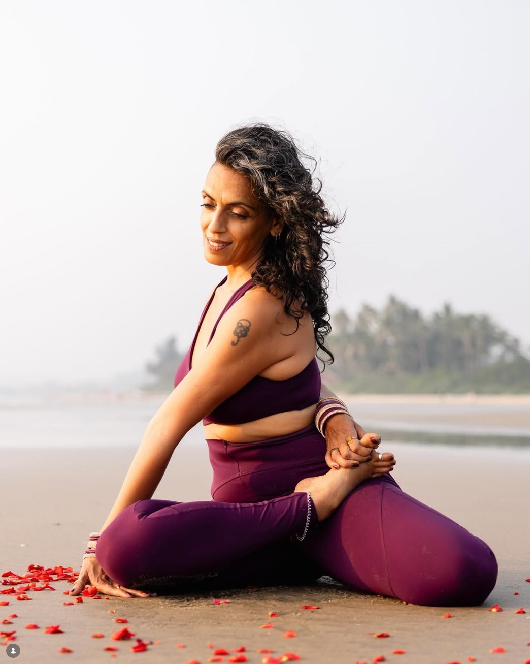 Tara practicing yoga on a beach