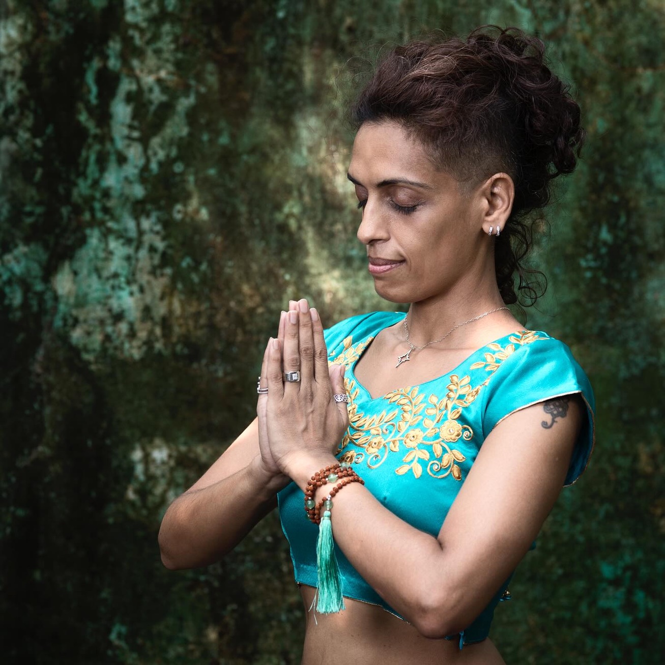 Tara in prayer among deep green rock